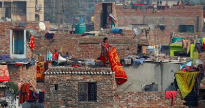A woman hangs a blanket out to dry, at a slum in New Delhi, India January 2, 2020. Photo: Reuters/Danish Siddiqui
