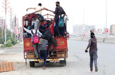 A migrant worker runs behind a truck as others try to board it to return to their villages after India ordered a 21-day nationwide lockdown to limit the spreading of coronavirus disease, in Ghaziabad,  March 26, 2020. Photo: Reuters/Adnan Abidi