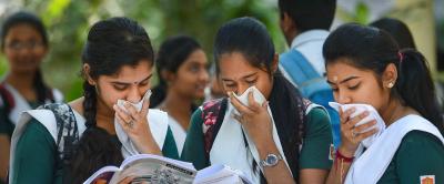 Twelfth standard class students, covering their faces to protect themselves from Covid-19, take a look of their notes before entering an examination hall, at a school in Chennai on Tuesday, March 24, 2020. Photo: PTI/R Gnanasasthaa
